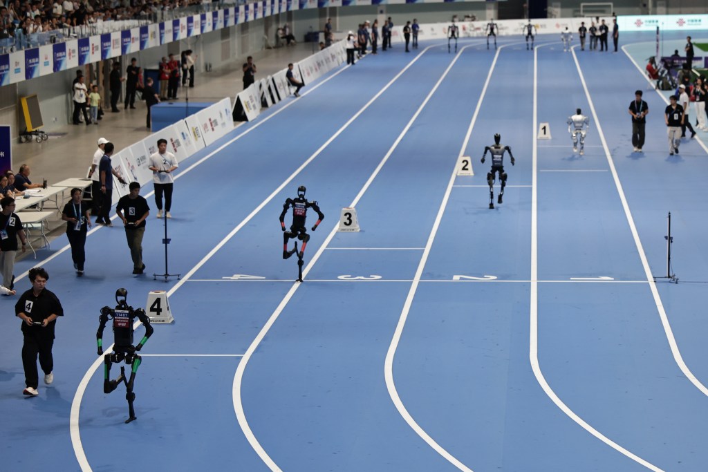 Robots humanoides y técnicos participan en la carrera de relevos final de 4x100 m durante los Juegos Mundiales de Robots Humanoides 2025 en el Óvalo Nacional de Patinaje de Velocidad en Pekín, China, el 17 de agosto de 2025. Los Juegos Mundiales de Robots Humanoides 2025 se celebraron en Pekín del 15 al 17 de agosto. 